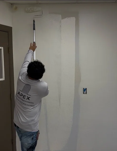 Professional painter applying interior paint to residential wall