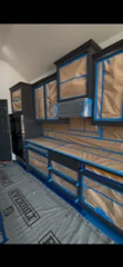 Blue painted wooden shelving unit with multiple storage tiers and reinforced support structure