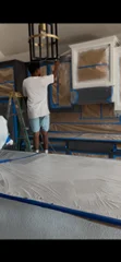 Interior wall painting with white paint application and protective floor coverings